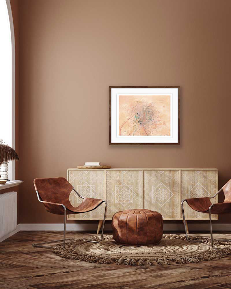 Framed giclée art print of original oil painting in boho african inspired interior—colorful abstract aerial view of Timbuktu, Mali in warm pink, coral, and desert tones.