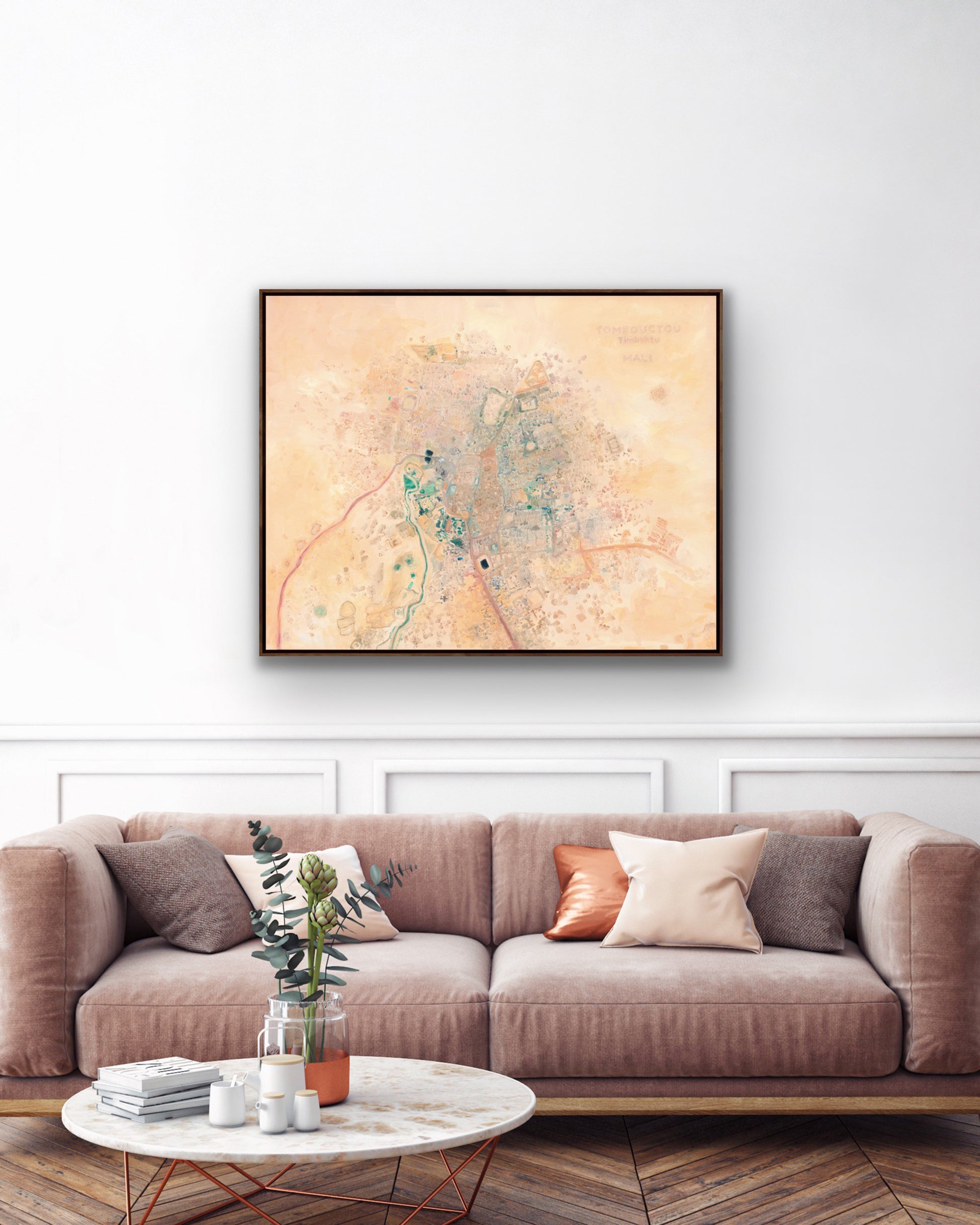 Framed stretched canvas art print in modern interior of a colorful abstract aerial view of Timbuktu, Mali in warm pink, coral, and desert tones.