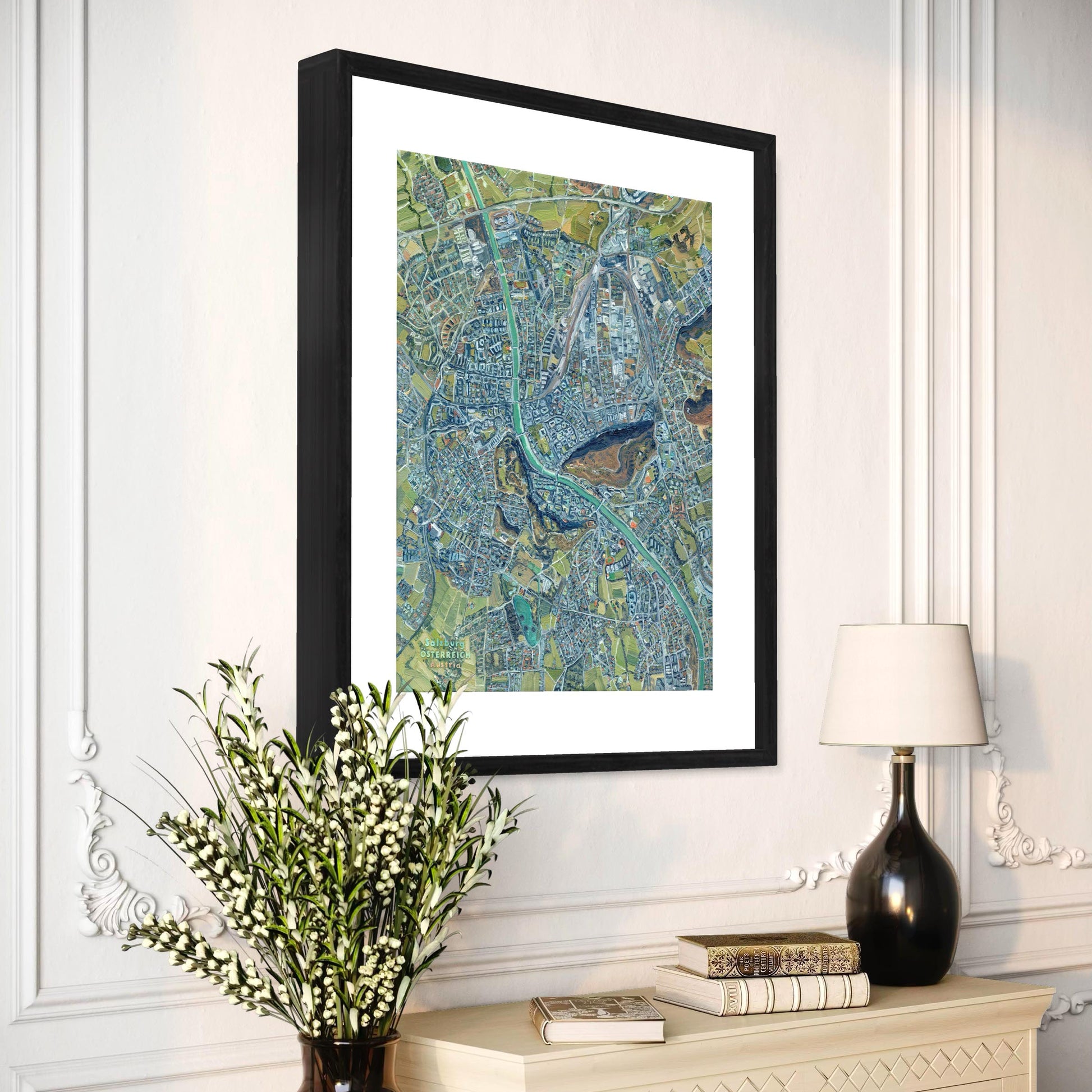 Framed abstract artwork on a wall above a dresser with decorative items.